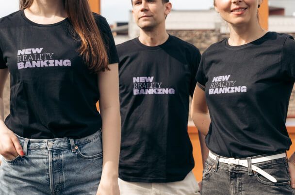 2 Frauen und 1 Mann, die Nuri (New Reality Banking) T-Shirts tragen. Urheberrecht: nuri.com